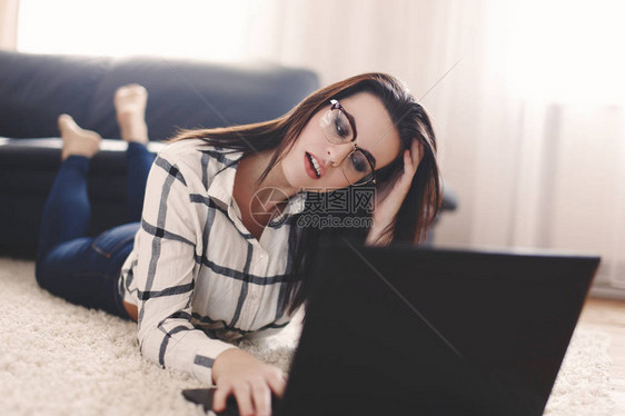 年轻女人在室内用笔记本电脑与某人交谈图片