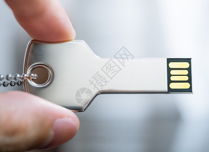 在技术安全概念中手握键形USB驱动器的图片