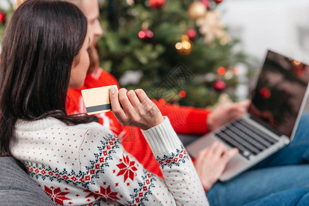在圣诞节用信卡和笔记本电脑在线购物的年轻夫图片
