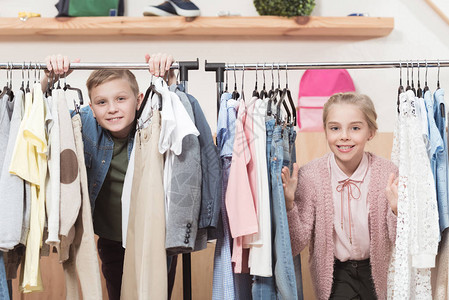 两个笑着的小孩在店里站在衣架图片