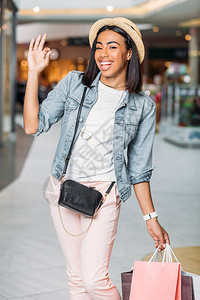 开心的时尚女人购物袋在商场图片