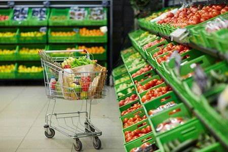 超市水果和蔬菜部安装有健康杂货食品的金属购物小卖车图片