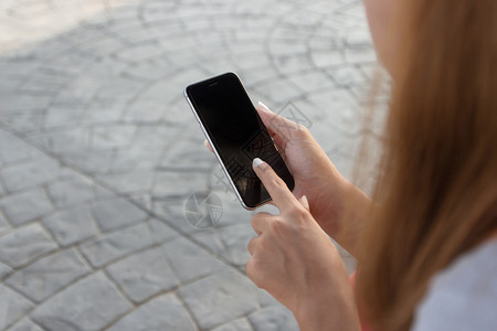 近身女接触手机在城市的背景图片