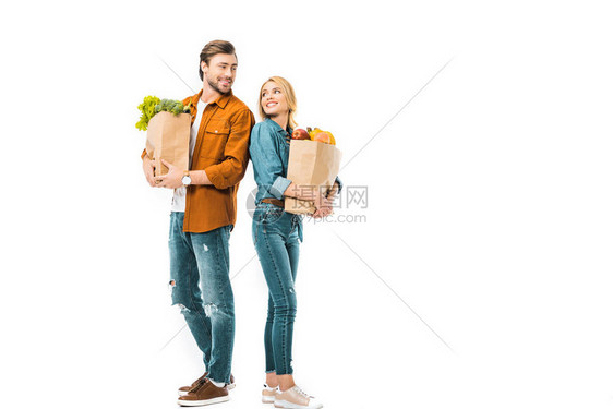 一对夫妇装满了商品袋的购物袋互相看着对方站在后背靠后图片