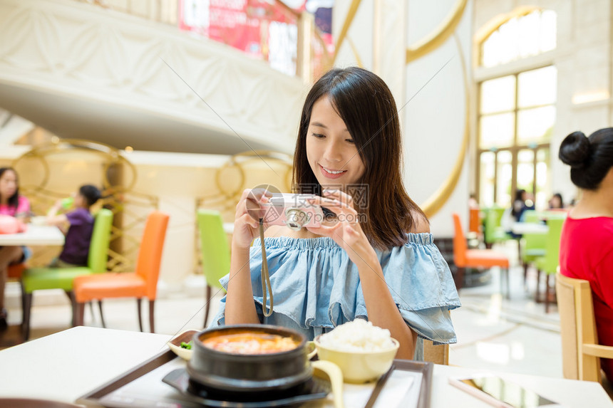 妇女在吃饭前在数码相机上拍照高清图片下载-正版图片503502847-摄图网