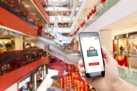 在现代购物中心在线购物的移动电话背景图片