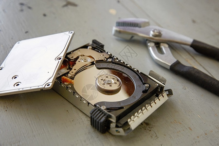 木桌上的损坏和损坏的硬盘驱动器磁盘图片