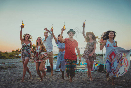 欢乐的一群朋友在海滩上庆祝和玩乐暑假的图片