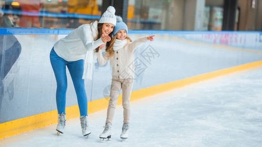 微笑着的母亲和女儿在滑冰图片