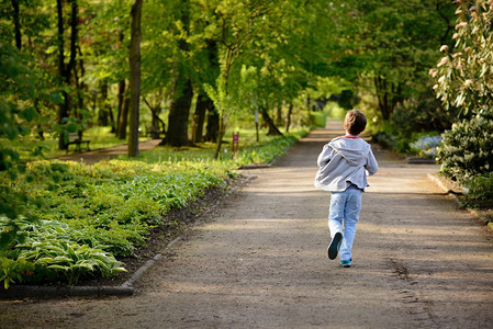 儿童节在公园里跑步的小男孩后视图图片