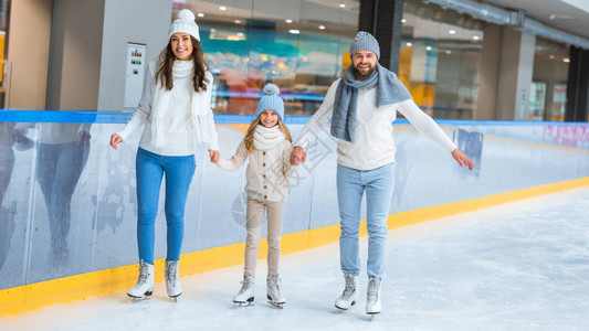 在溜冰场上一起滑冰时手牵的幸福家庭图片