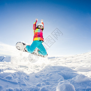 女孩在她的滑雪板跳跃中玩得开心图片