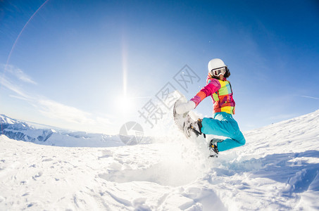 女孩在她的滑雪板跳跃中玩得开心图片