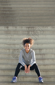 脚步一位快乐的非洲年轻运动女运动员的肖像坐在背景