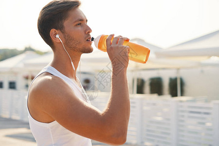 体育概念男子在锻炼后喝水口渴的健康男与健康的身体喝清凉饮料跑步或户外训练图片