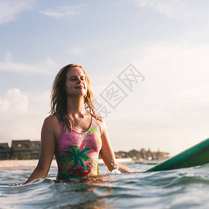 穿着泳衣的年轻女子在海洋冲浪板图片