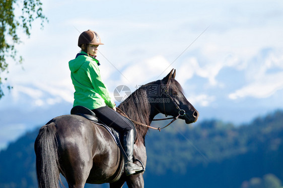 在山上骑马的年轻女图片