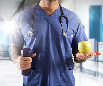 具有苹果和哑铃重量的男医生体育活动和健图片