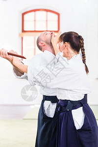 在武术学校Aikido训练中用木刀打架图片