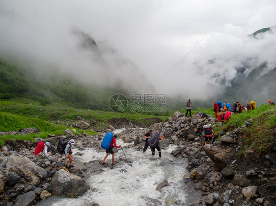 徒步旅行者小组穿过山区河流福特图片