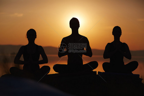一群人在日落时练习瑜伽图片