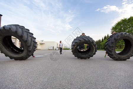 健身小组或球队在户外翻滚重轮胎个人图片