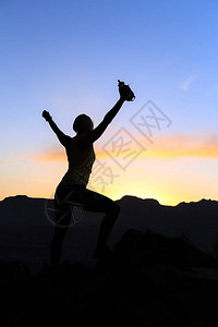 女徒步旅行者登山者或越野跑者在山顶上张开双臂图片