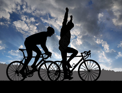 日落时骑着公路自行车的两名骑自图片