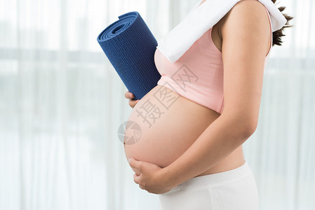 育有力的孕妇用瑜伽垫背景图片