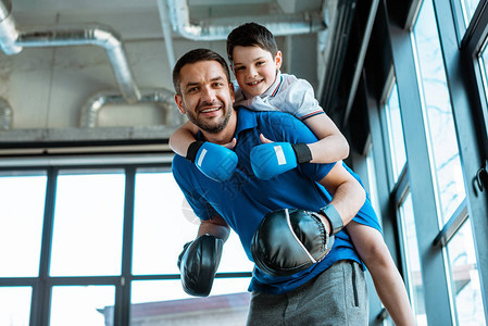 快乐的父亲在健身房拳击手套上给快乐图片