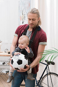 拿着足球带着儿子和孩子的父亲在婴儿赛图片