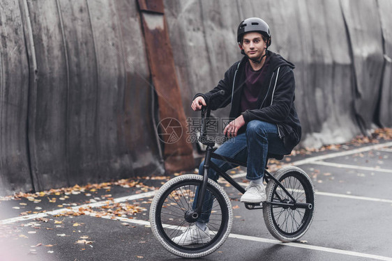 身戴头盔的青年男子骑着bmx自行车在街图片