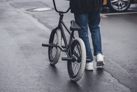 男孩在街上骑着bmx自行车走图片