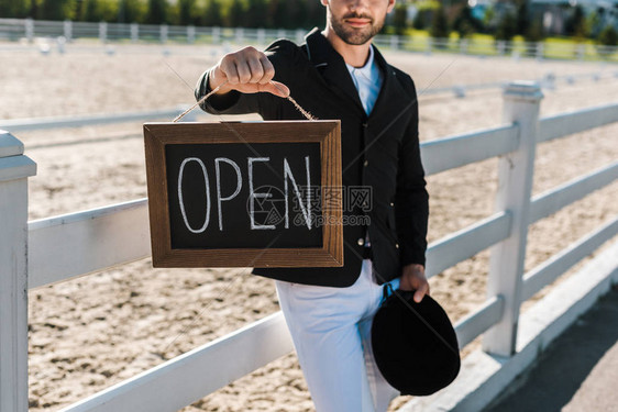 男马术士靠在围栏上并在马匹俱乐部显示开放标图片