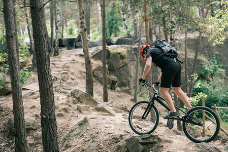 保护头盔骑在森林中的山上自行车时的男极图片