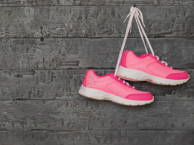 木墙背景上的一双粉红色运动鞋运动生图片