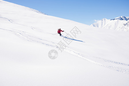 一个人在意大利阿尔卑斯山的雪坡上滑下脚踏板图片