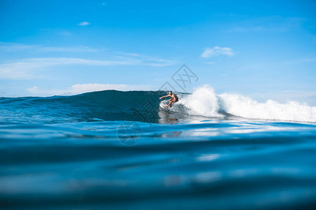 在阳光明媚的海洋中骑在海浪上的年图片