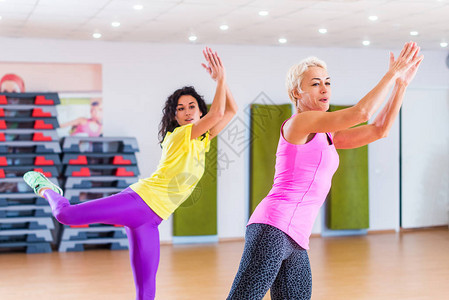 快乐的女运动员在健身中心进行有氧运动或Zumba舞蹈锻炼图片