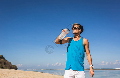 沙滩上运动瓶里饮用水的饮水在图片