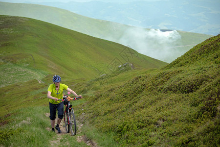 骑自行车的人在山上推自行车图片