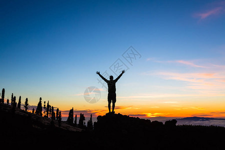 越野跑者徒步旅行者或登山者举起双手到达山顶图片