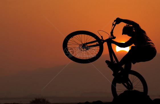 日落一个骑摩登自行车的男人图片
