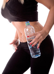 身体健康的女人拿着一瓶水在锻炼后图片