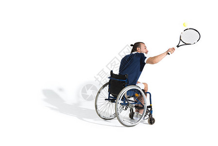 坐在轮椅上打网球的残疾青年运动员在白图片