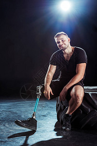 手脚假肢的麻利运动员坐在轮胎上图片