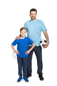 父亲和儿子在踢足球时微笑看着白图片