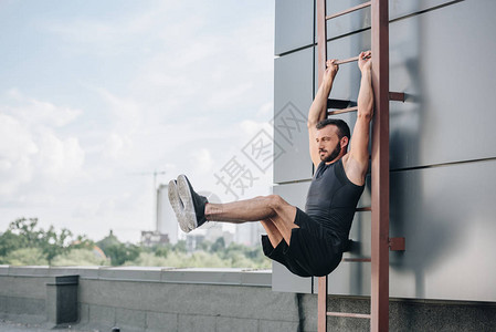 健壮的运动员腿在屋顶梯图片