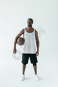 身穿运动服的英俊的非洲男子穿着篮球在图片
