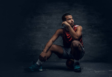 坐在篮球上的一个黑人篮球运动图片